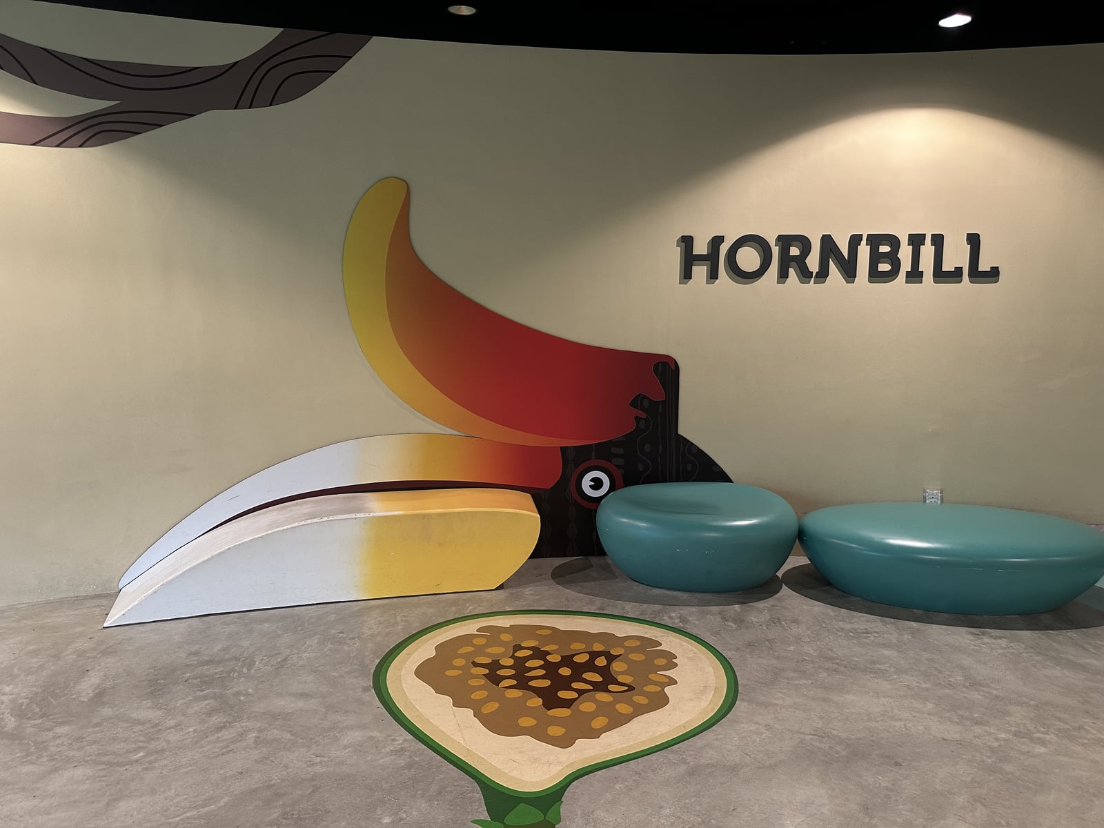 A beak-shaped bench continuing a bird mural on the wall