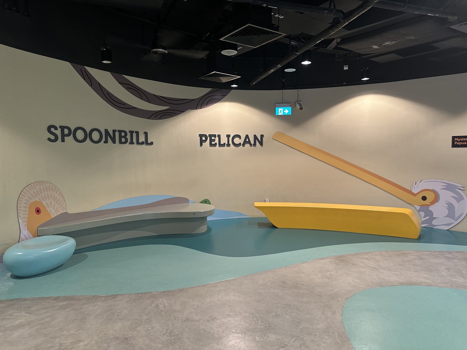 Long beak-shaped benches arranged with painted birds on the wall