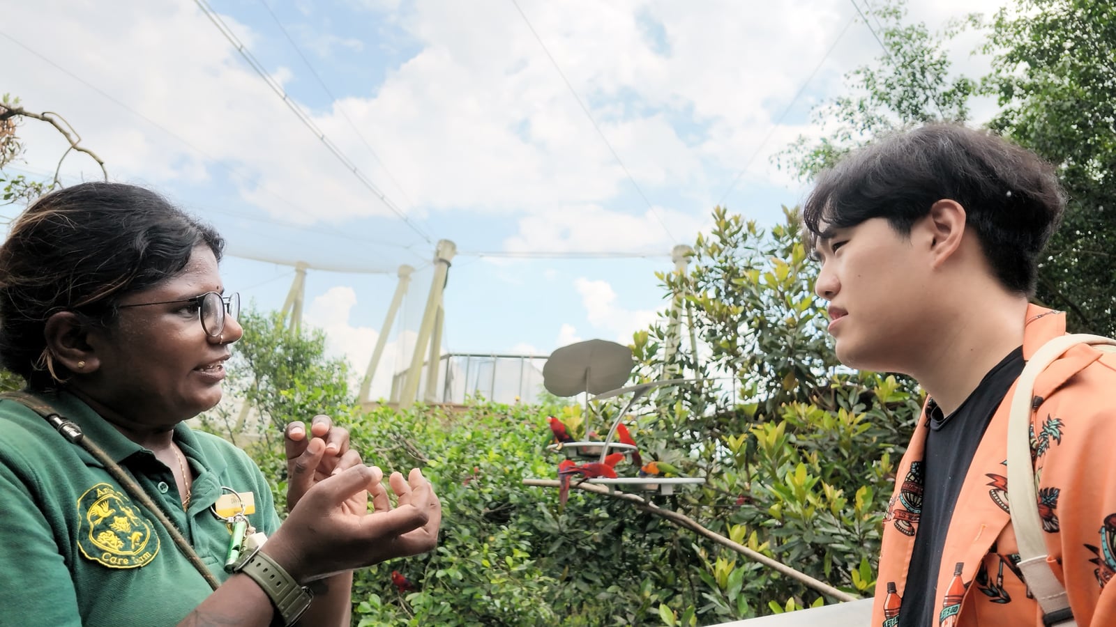 A Naviary breeder listening to a keeper beside an aviary